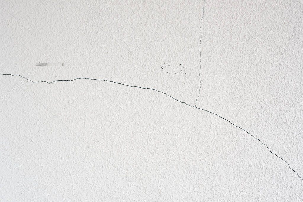 Crack in a white wall of a house that is being remodeled