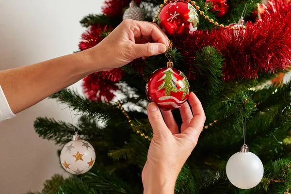 Close-up of a womans hands decorating a christmas tree — Stock Photo, Image