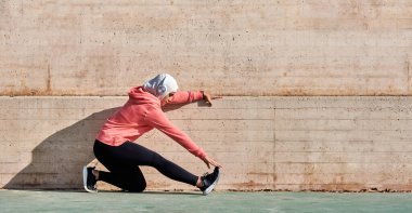Müslüman sporu yapan kadın esneme hareketleri giyiyor.