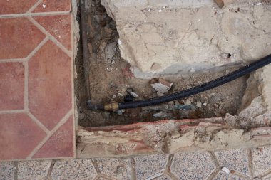 Evin borularında sızıntı bulmak için kazılmış toprak.