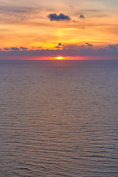 Схід сонця в морі з хмарами в небі і синіми і помаранчевими кольорами — стокове фото