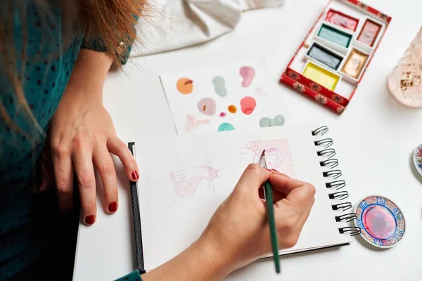 Ressam kadın suluboya çizimler yapıyor.