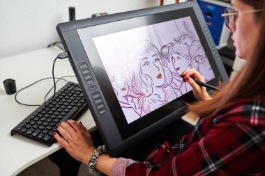 Beyaz kadın ressam, Stylus ile dijital tablet üzerine resim çiziyor.