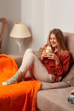 Kadın kanepede bir tilkiyle dinleniyor.