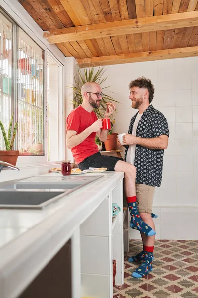 Two gay men in the kitchen drinking coffee — Stock Photo, Image