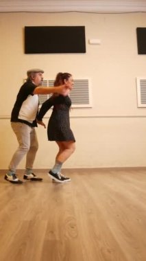 Dans eden yetişkin bir çift stüdyoda dans ediyor.