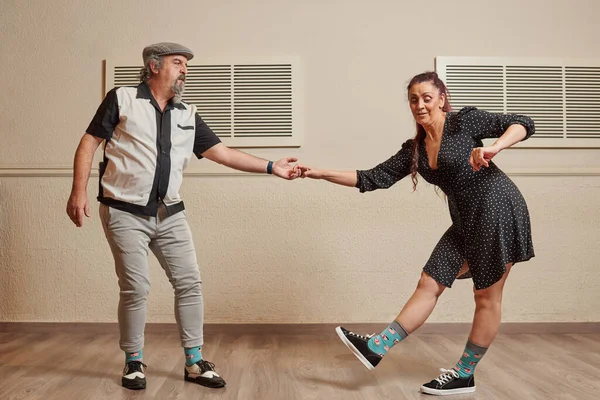 Senior adult couple dancing lindy hop in a ballroom Stock Picture