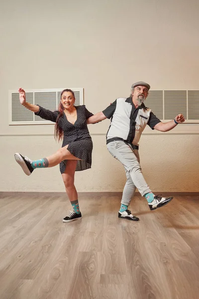Senior adult couple dancing lindy hop in a ballroom Stock Picture
