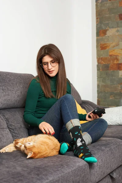 Woman caresses her cat on the sofa Stock Picture