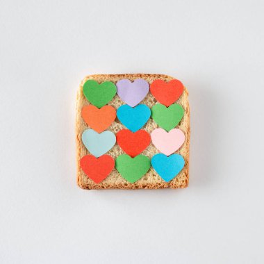 Kadeh kaldırırken renkli kağıt kalpler. Aşkın ve yemeğin minimalist konsepti