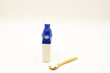 Beyaz arka planda bir yığın hap. Beyaz arka planda beyaz bir kavanozdan beyaz haplar düşüyor..