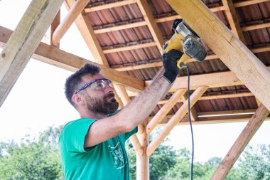 İşçi kendi çalışma yerinde köşeli öğütme makinesinin ahşabını öğütüyor. Çalıştığımız odun kadar sağlam.
