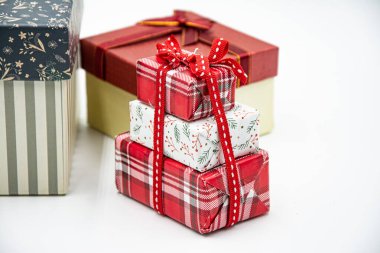 Kurdeleli üç hediye kutusu ve beyaz arka planda Noel ağacı dalı..