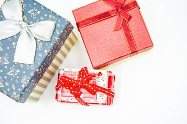 Kurdeleli üç hediye kutusu ve beyaz arka planda Noel ağacı dalı..