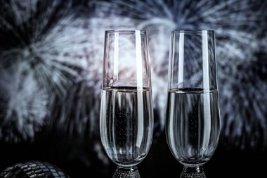 Şampanya bardakları ışıl ışıl arka planda. İki şampanya kadehi yeni yıla hazır..