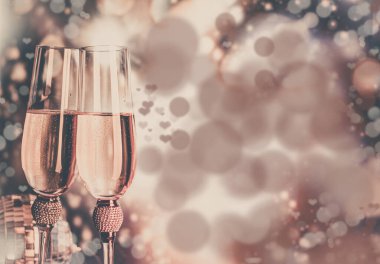 Şampanya bardakları ışıl ışıl arka planda. İki şampanya kadehi yeni yıla hazır..
