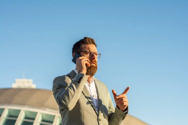 Taşınabilir yaşam tarzı. Yeni teknoloji. Dışarıda cep telefonu olan yakışıklı bir adam. İş iletişimi. Profesyonel kullanım için telefon. 3G mi? 4G mi? 5G mi? Şehir merkezinde telefonu olan bir iş adamı.