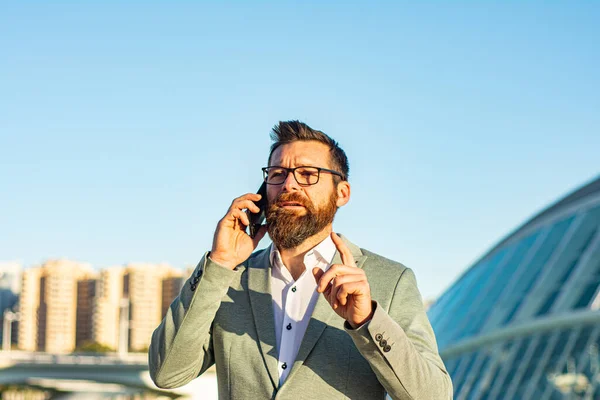 Taşınabilir yaşam tarzı. Yeni teknoloji. Dışarıda cep telefonu olan yakışıklı bir adam. İş iletişimi. Profesyonel kullanım için telefon. 3G mi? 4G mi? 5G mi? Şehir merkezinde telefonu olan bir iş adamı.