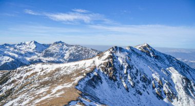 Kış dağlarının manzarası. Rodna Dağları. İnsansız hava aracının zirvesinden bir dağın havadan görünüşü.