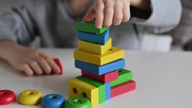 Bir çocuk renkli, eğitici tahta bir oyuncakla oynuyor. Çocuk Ahşap Oyuncak