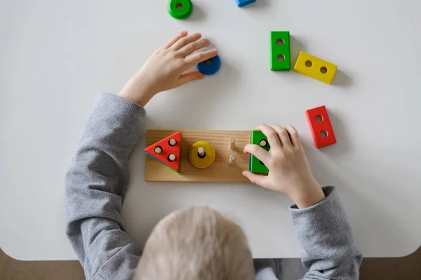 L'enfant recueille un jouet en bois coloré.Tri logique multicolore.. — Photo