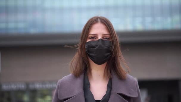 Молодая женщина снимает медицинскую маску в центре города и вдыхает воздух. — стоковое видео