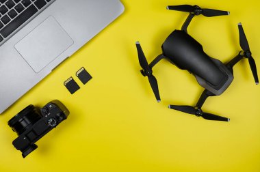 Modern gezginin düzeni: Kamera, Drone, hafıza kartları, sarı arkaplanda bilgisayar