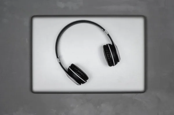 Portátil con auriculares estéreo inalámbricos sobre fondo gris. — Foto de Stock
