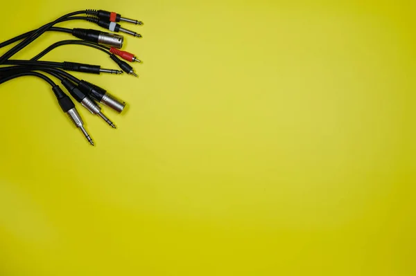 Diseño de varios cables de audio en un fondo amarillo.Espacio de copia — Foto de Stock