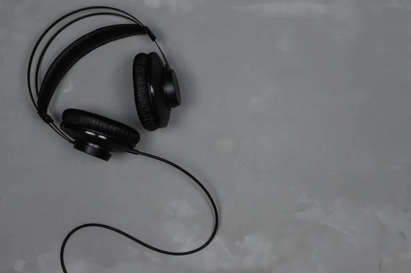 Black headphones on a gray background. Top view.Copy space — Stock Photo, Image