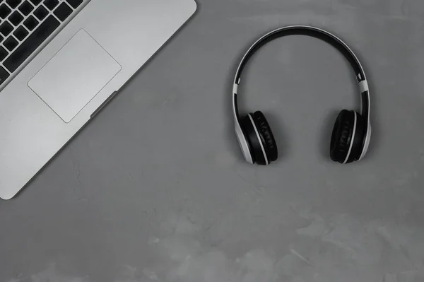 Diseño de un portátil con auriculares estéreo sobre un fondo gris. — Foto de Stock