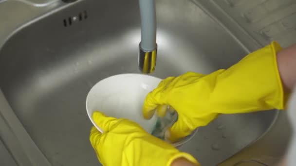 Ruce ve žlutých ochranných rukavicích naneste prací prostředek a umyjte talíř — Stock video