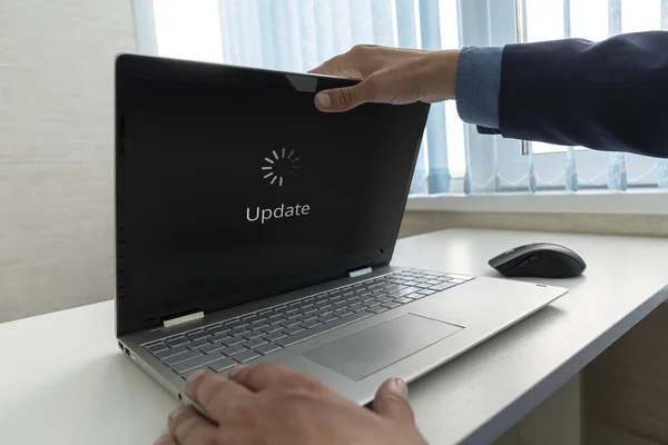 Yazılım Teknolojisi Yükseltme Konsepti güncelleniyor. Bir iş adamı, işletim sisteminin güncellendiği modern bir ultrabook açar..