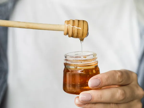 Mão segurando doce pote de mel. Conceito de foto bonita de alta qualidade — Fotografia de Stock