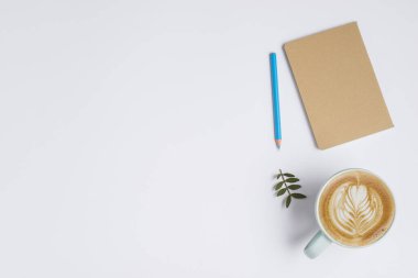 Kapalı defter renkli kalem kapaklı kahve ve beyaz latte tablosu. Yüksek kalite güzel fotoğraf konsepti