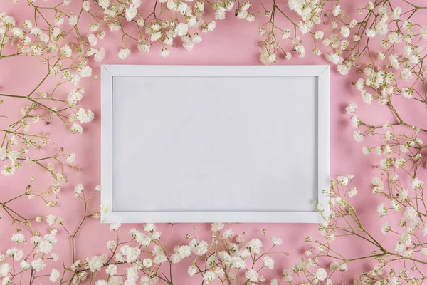 Puste białe puste ramki otoczony białym dzieckiem s kwiaty oddech na różowym tle. Wysokiej jakości piękne zdjęcie koncepcja — Zdjęcie stockowe
