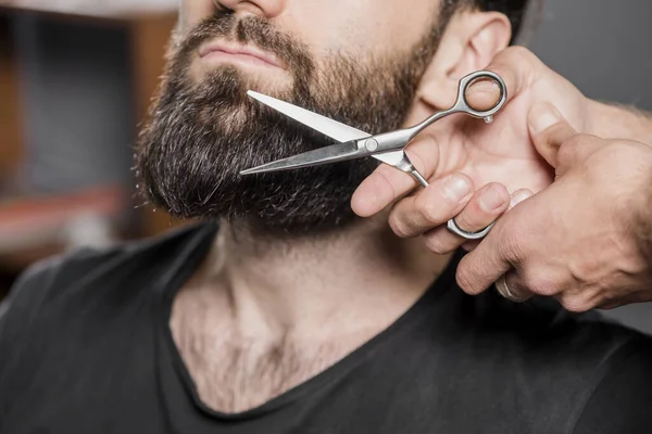 Hairstylist s hand cutting man s beard with scissors. High quality beautiful photo concept — Stock Photo, Image