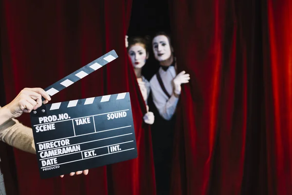 Personne tenant clapperboard devant mime couple debout rideau rouge. Haute qualité beau concept photo — Photo