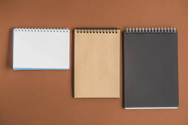 Tres cuadernos en espiral fondo marrón. concepto de foto hermosa de alta calidad —  Fotos de Stock