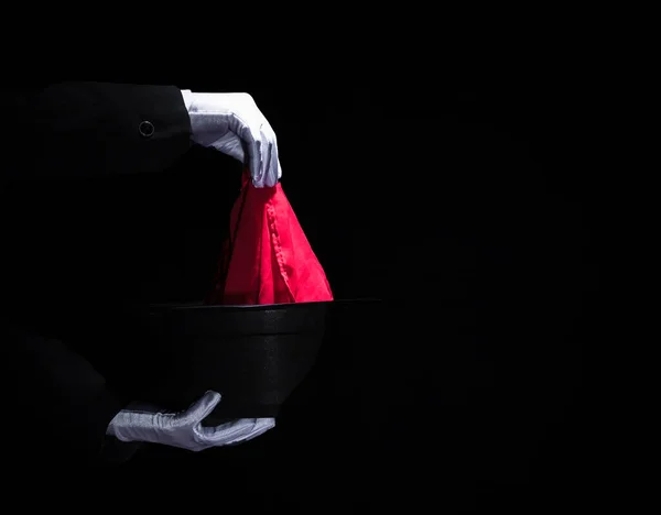 Zauberhand führt Zaubertrick mit Serviettenoberteil schwarzen Hut. Hochwertiges Foto — Stockfoto