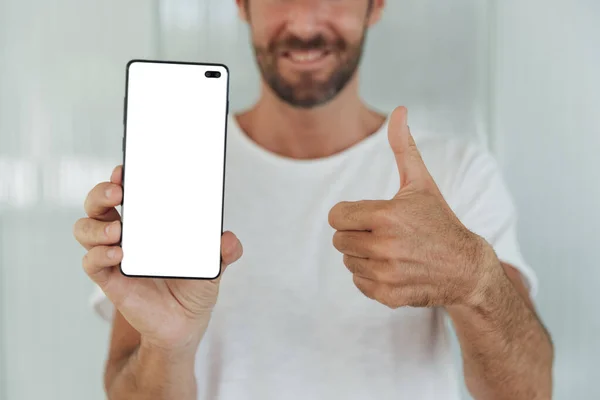 Homem barbudo mostrando o telefone com o polegar para cima. Foto de alta qualidade — Fotografia de Stock