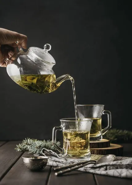 Vorderseite Hand gießt Teeglas mit Teekanne — Stockfoto