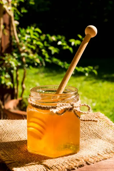 Honigglas mit Löffel — Stockfoto