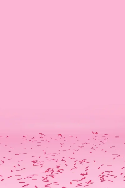 Konfetti elszórt rózsaszín háttér — Stock Fotó