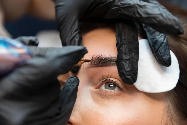 Jovem mulher recebendo tratamento de beleza suas sobrancelhas. Foto de alta qualidade — Fotografia de Stock