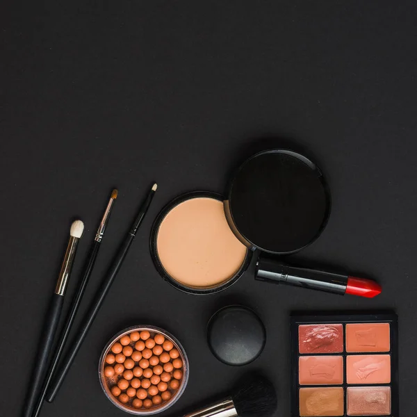 Produtos de maquiagem vista aérea com pincéis fundo preto. Foto de alta qualidade — Fotografia de Stock