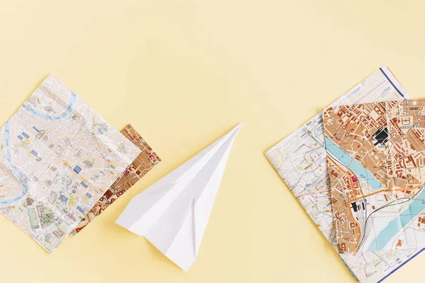 Változatos térképek fehér papír repülőgép bézs háttér. Kiváló minőségű fénykép — Stock Fotó