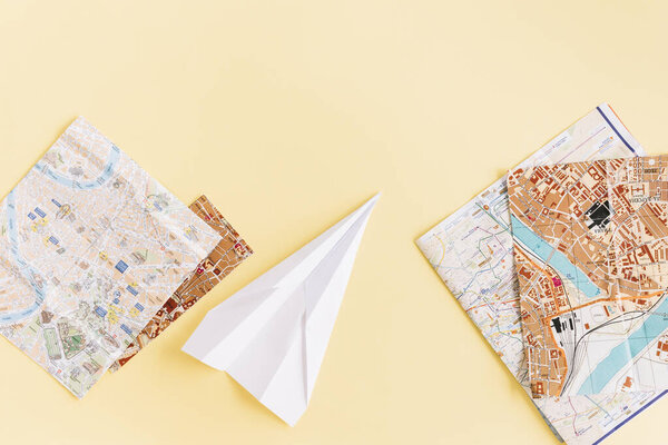 variety maps with white paper airplane beige background. High quality photo