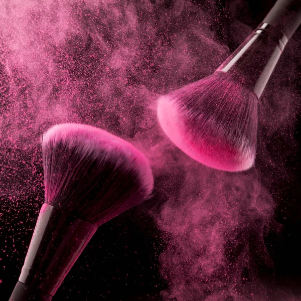Twee cosmetische borstels roze poeder donkere achtergrond. Hoge kwaliteit foto — Stockfoto