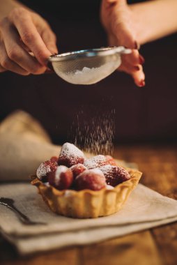 Şeker tozlu çilekli tart yiyen bir kadın. Yüksek kalite fotoğraf